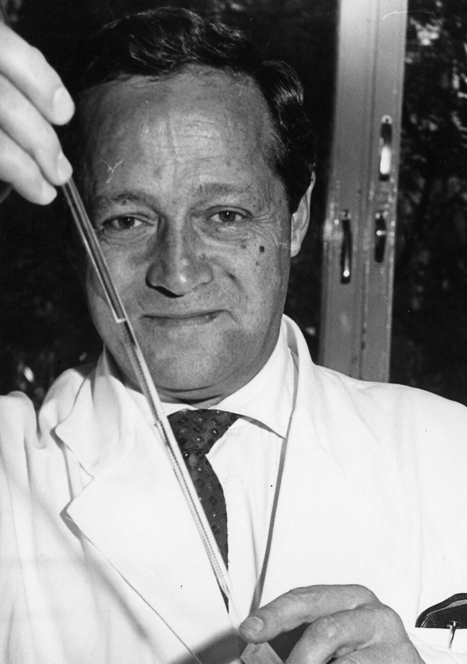 Black-and-white photograph of Feodor Lynen working with a laboratory pipette