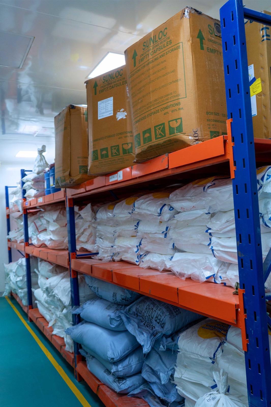 Approved raw-material bags and component cartons arranged on identified storage racking