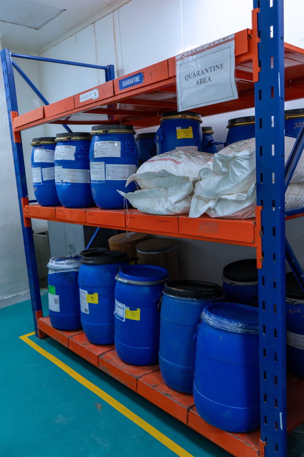 Blue drums and raw-material bags held on identified quarantine racking