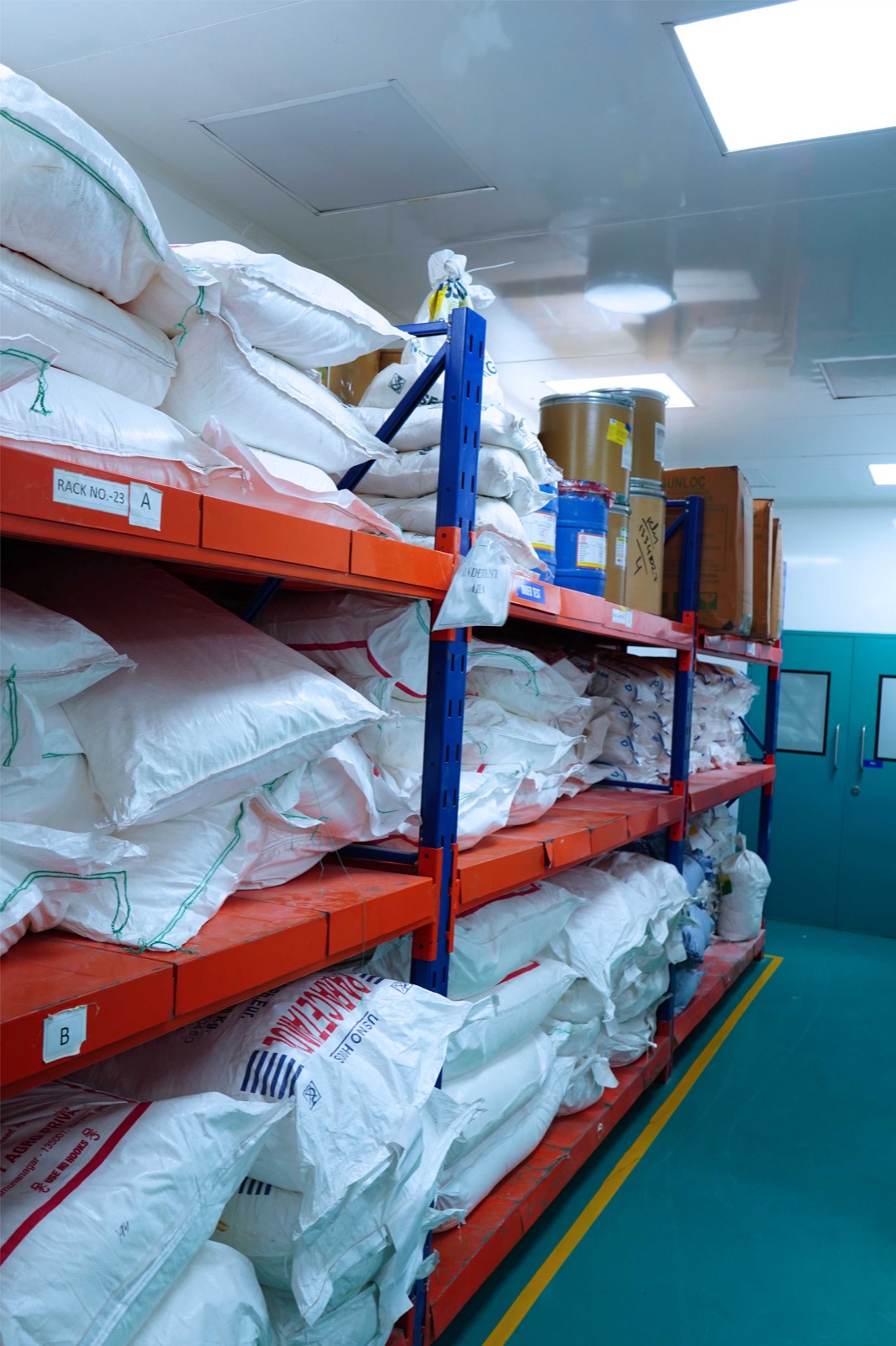 Raw-material bags and containers arranged on identified racking in the under-test storage area